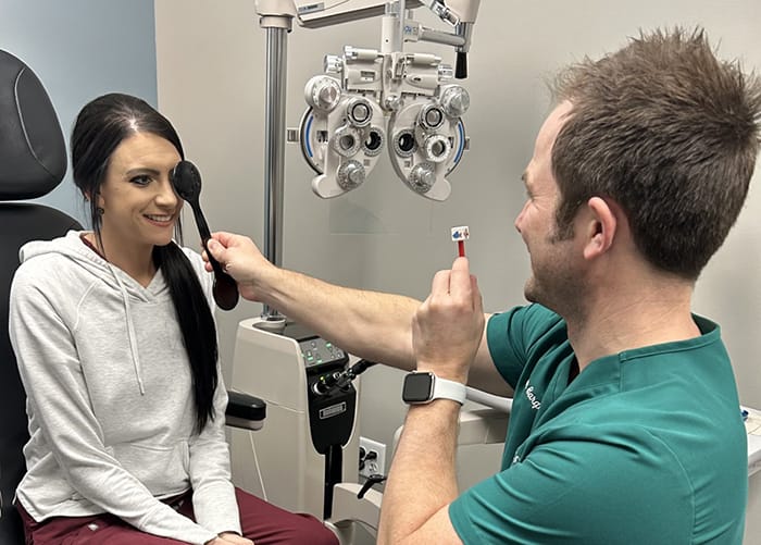 Doctor performs an eye exam on an adult patient.